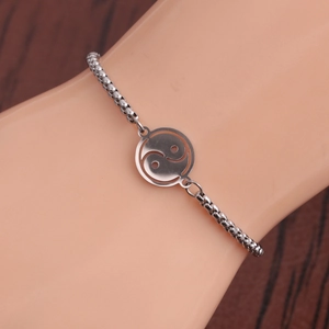 Polished stainless steel Yin Yang bracelet with adjustable chain on a model wrist