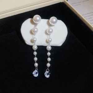 Macro shot of long drop tassel earrings with white pearls and teardrop cubic zirconia