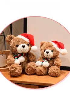 Close-up of two brown plush Christmas teddy bears with red scarves on wooden table