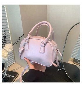 Close-up of pink textured PU leather Boston bag with silver zippers and handles