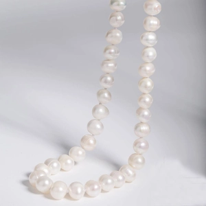 Detailed view of natural white freshwater pearls on a 925 silver necklace chain