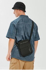 Rear view of man wearing black waterproof crossbody bag with adjustable nylon strap