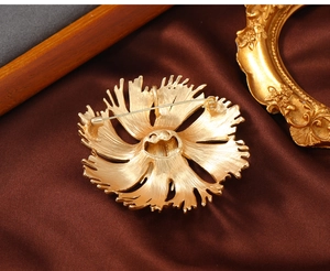 Detailed back view of vintage matte gold flower brooch showing metal texture and pin