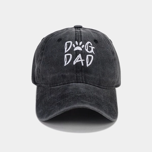 Detail of white DOG DAD embroidery on dark gray washed cotton baseball cap texture