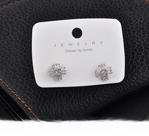 Close-up of sparkling star-shaped zircon stud earrings with 925 silver posts on a white card