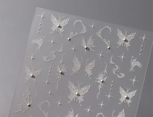 Detailed close-up of 3D embossed butterfly nail stickers with delicate pearls and stars