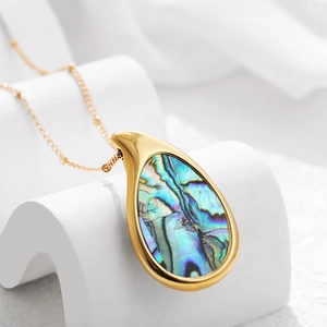 Macro detail of teardrop 18k gold plated necklace with rainbow abalone shell inlay