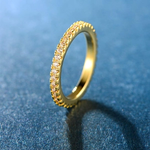 Elegant gold-plated eternity ring with pavé-set zircons on a dark navy background