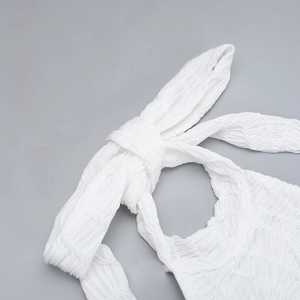 Detailed view of the halter neck tie and white textured seersucker fabric on this dress