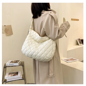 Detailed macro view of the large white quilted shoulder bag with soft textured hobo design