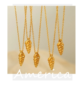 Detailed macro view of gold-finished spiral conch pendants on minimalist chain necklaces