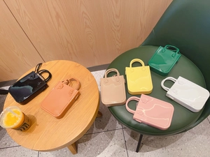 Colorful mini PVC jelly handbags in seven vibrant shades displayed on a wooden table