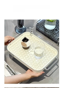 Detail of cream white rectangular tray with dual-layer drainage and metal handles