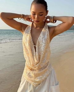 Détail du haut licou à paillettes champagne avec col en V profond et broderie sur la plage