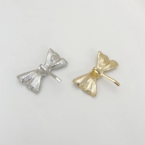 Detailed view of minimalist gold and silver bow hair clips with secure metal back clasps