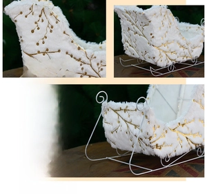 Detail of white plush Christmas sleigh decor with golden foil branch patterns and iron frame