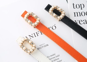 Three leather skinny belts in black, orange and white with pearl rhinestone buckles