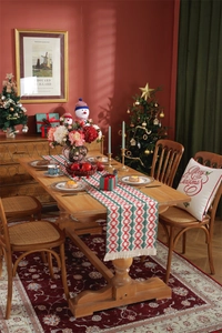 Festive Christmas table runner featuring red and green geometric patterns and white tassels