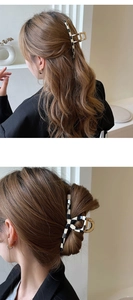 Detail of large checkered hair claw clip with golden metal base worn on brunette hair
