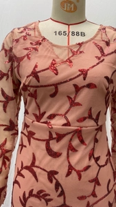 Detailed view of sequin embroidery and sheer mesh fabric on this pink evening dress