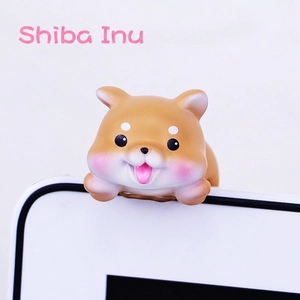 Close-up of a Shiba Inu mini ornament hanging on a screen edge for car or desk
