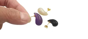 Close-up of teardrop moonstone and amethyst stud earrings with gold pins in three colors