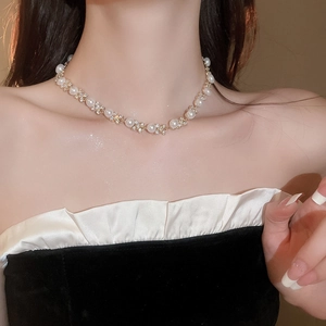 Dettaglio dell'elegante collana d'oro con perle bianche e accenti di diamanti lucidi