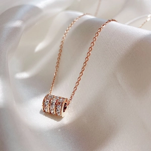 Close-up of rose gold waist pendant with sparkling zircons on white silk background