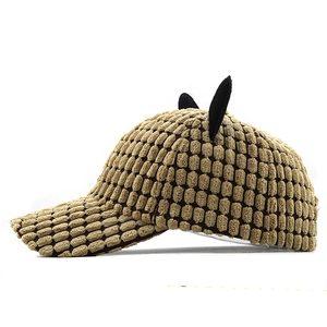 Detailed side view of brown corduroy baseball cap featuring cute black bear ear accents