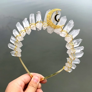 Detail of natural white crystal quartz crown with gold wire moon and star pendant