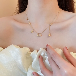 Detail of 18k gold plated flower and bag pendants on a vintage-style dainty necklace