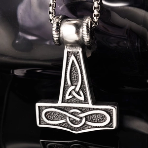 Détail macro du pendentif Mjölnir avec nœuds vikings et finition argent vintage