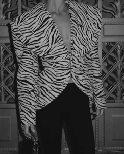 Detail of zebra print blazer with wide lapel shown in elegant architectural setting