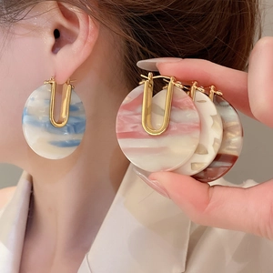 Détail de boucles d'oreilles en U plaquées or 18 carats avec pendentifs en résine marbrée