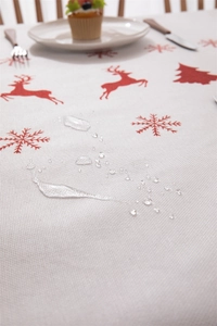 Detailed close-up of water droplets on waterproof Christmas tablecloth with reindeer pattern