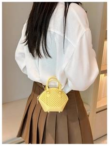 Detail of yellow woven mini jelly bag with golden chain strap and shell shape