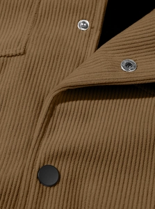 Detail of brown corduroy shirt featuring ribbed texture and metal snap buttons