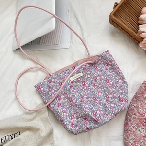 Vue à plat du sac cabas en toile à fleurs avec anses roses et étiquette de marque