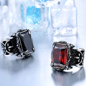 Macro shot of gothic steel rings with red and black stones resting on ice cubes