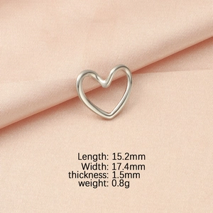 Detail view of heart-shaped silver pendant with size specs on pink velvet background
