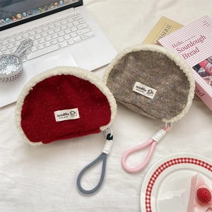 Detail of plush拼接 shell cosmetic bags in dark red and brown with woven lanyards