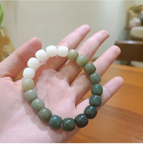 Macro shot of gradient white to emerald green weathered bodhi seed bead bracelet