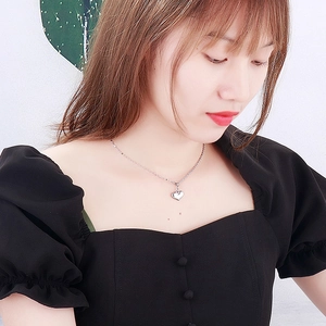 Primo piano della collana con ciondolo a cuore d'argento su una modella
