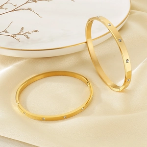 Detailed view of a gold-plated stainless steel bracelet featuring paved white zircons