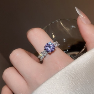 Macro shot of silver ring featuring a purple zircon main stone and claw setting