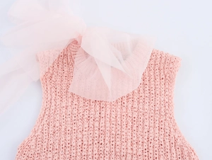 Detail of pink knit top featuring a large sheer organza bow on the sleeveless neckline