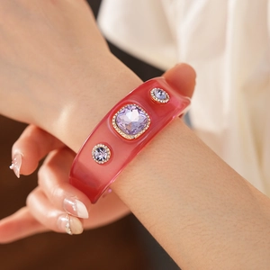 Detailed shot of vintage resin bangle with purple crystals on a woman's wrist