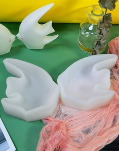 Detailed view of DIY silicone molds and white abstract bird crafts for handmade candles