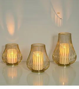 Three-piece gold hollow metal candle holders with warm electronic pillar candles inside