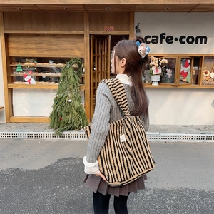 Détail du grand sac peluche à rayures marron et noir avec bandoulière épaisse au café